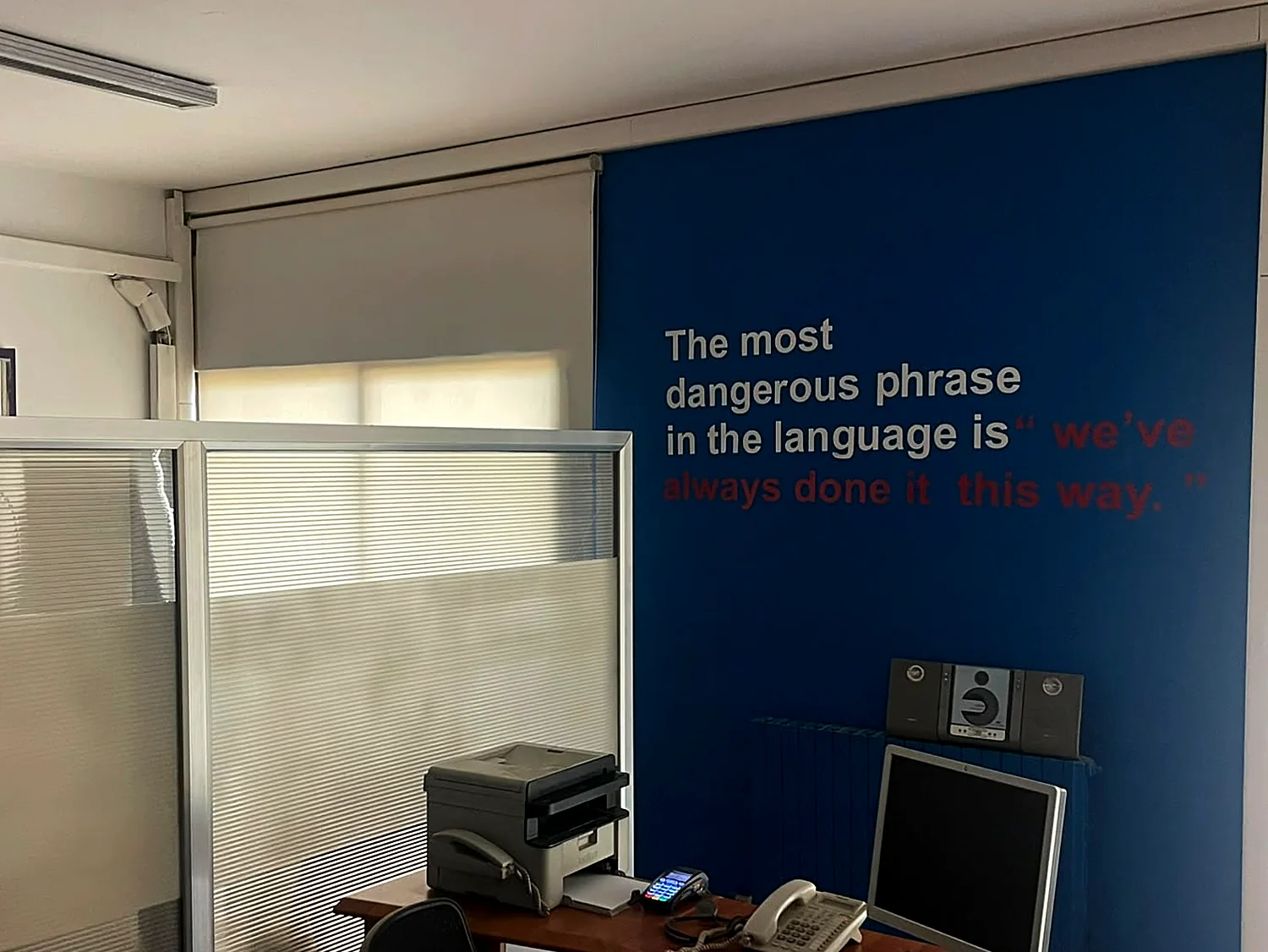 A blue wall at the Besiders office with the quote: The most dangerous phrase in the language is we have always done it this way